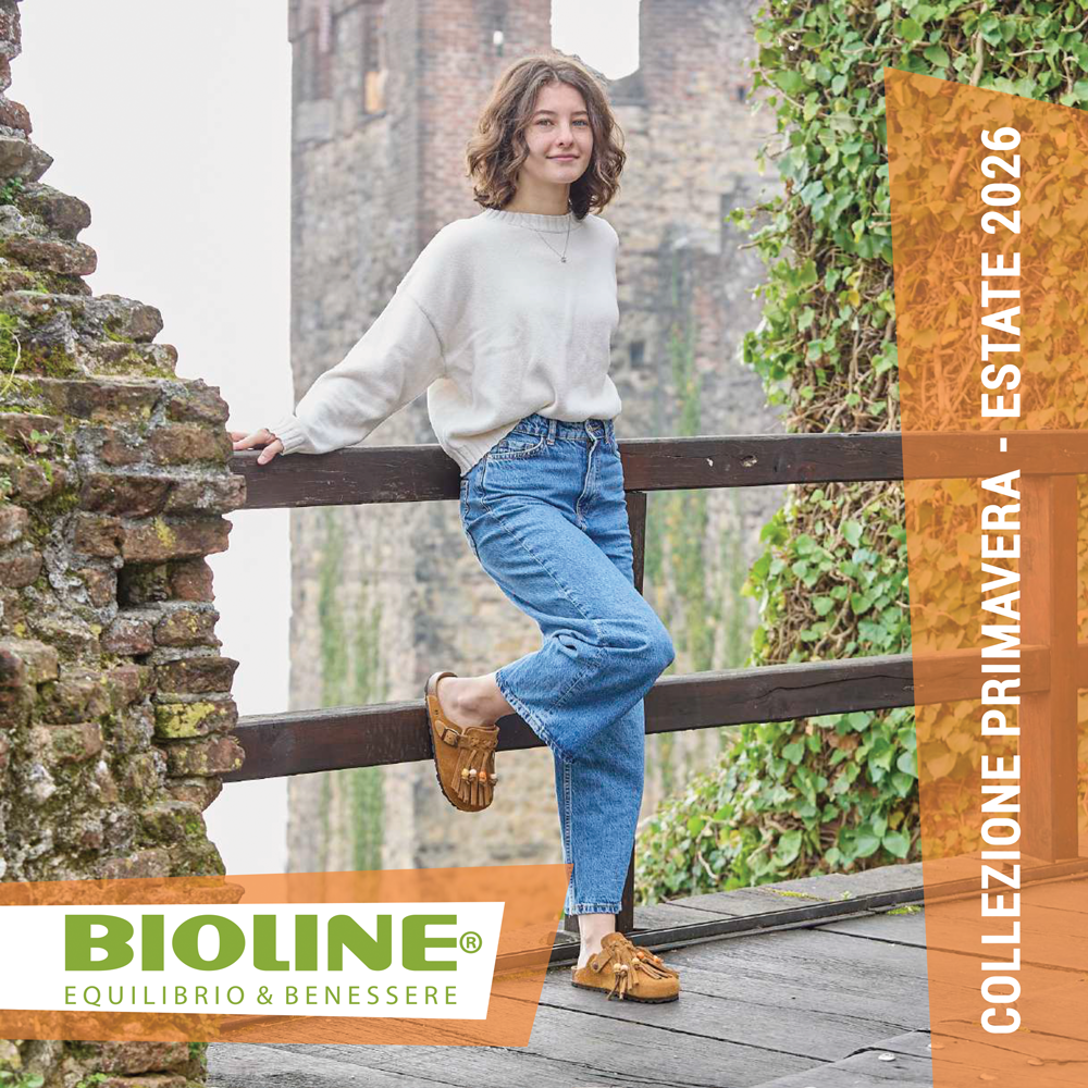 Una persona con scarpe Bioline arancioni si trova su rocce bagnate all'aperto.